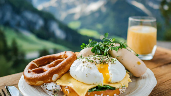 Egg Benedict mit Weißwurst und Laugengebäck zum Frühstück.